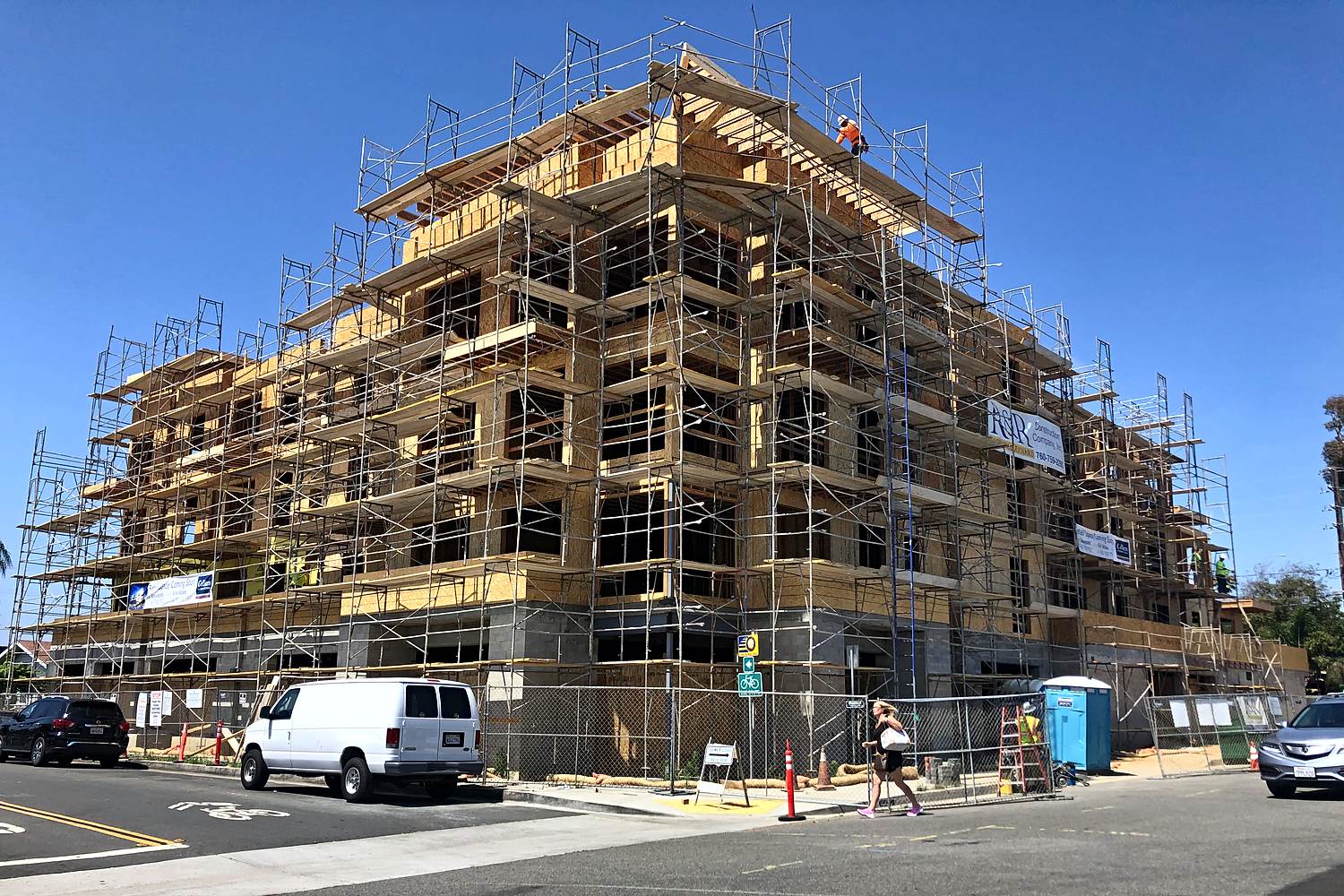 Street-level view of multi-story wood framing under scaffolding