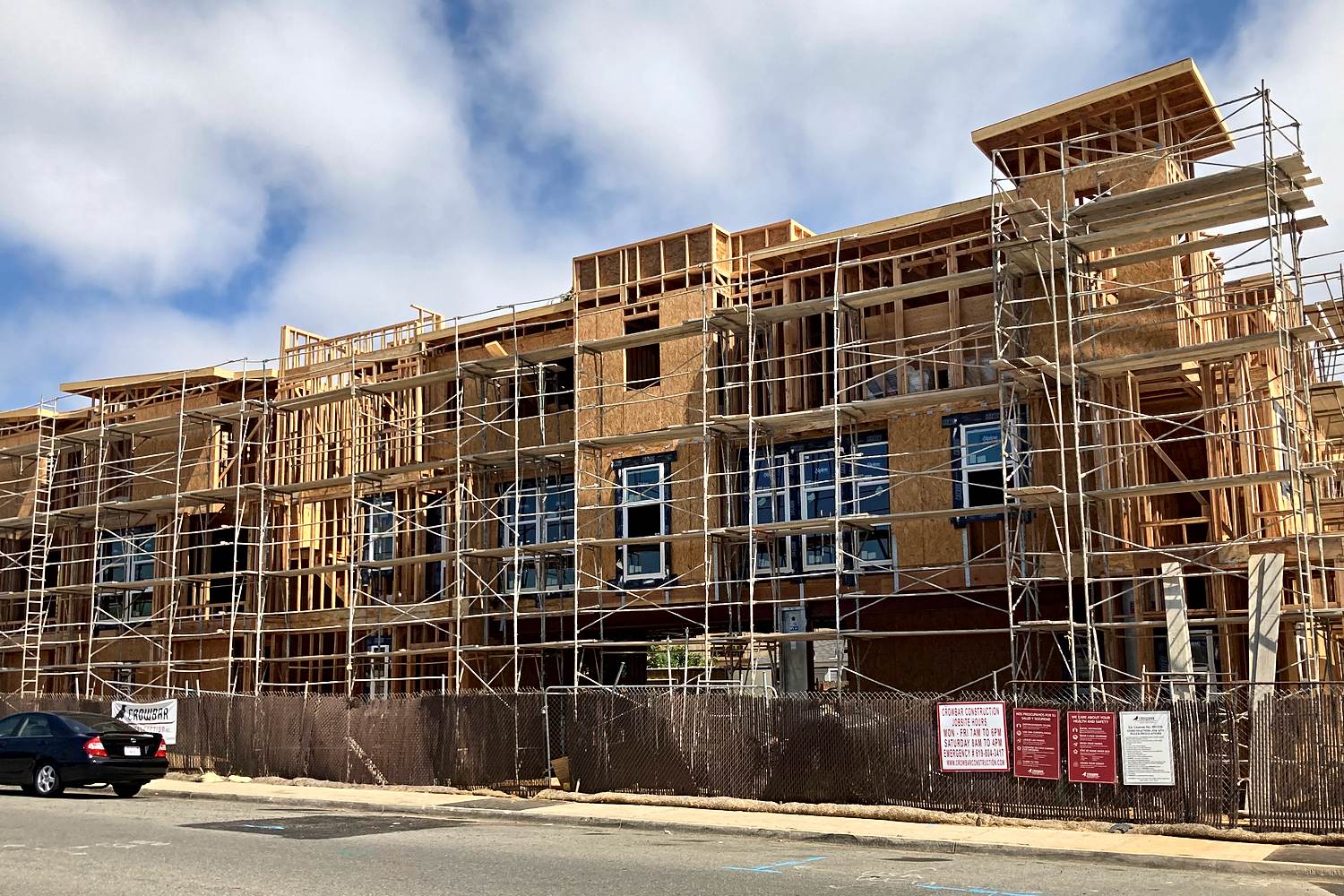 Sheathed multifamily facade under scaffolding