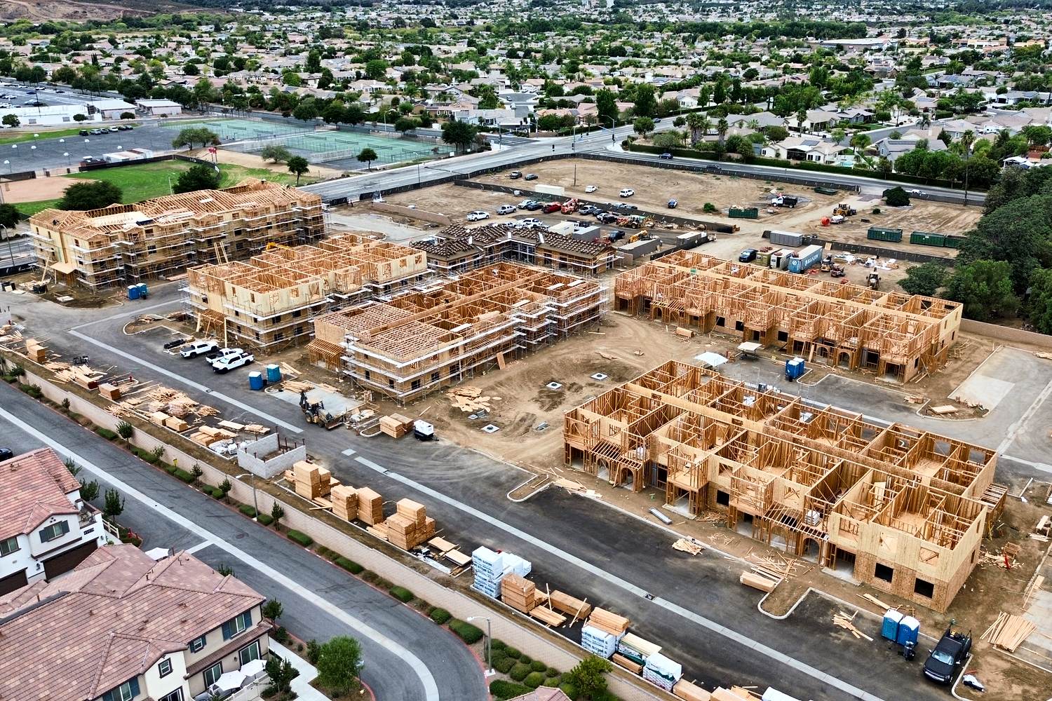 Aerial of hillside multifamily rough carpentry across multiple buildings