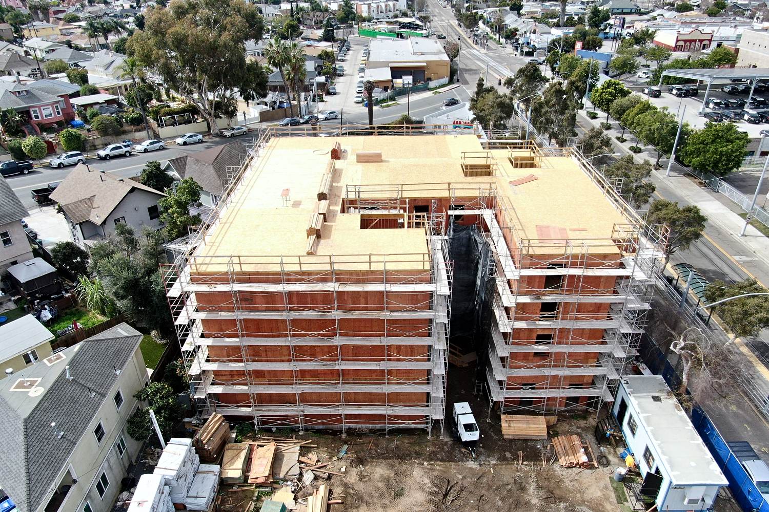 Aerial of sheathed multifamily framing near urban streets